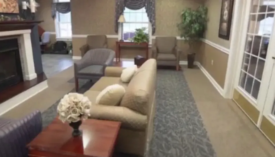 A lounge area with vaulted ceilings a fireplace with chairs, sofas, and tables