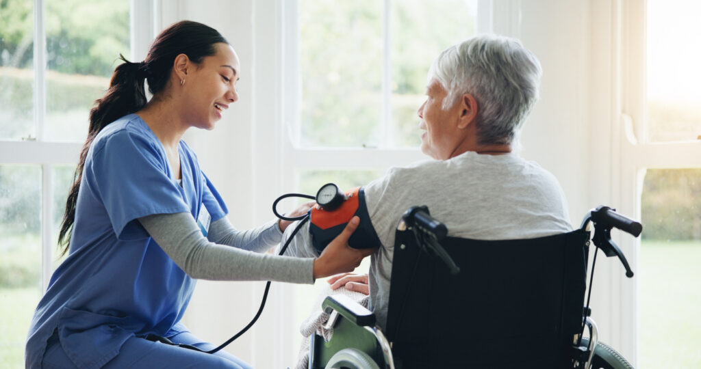 A female nurse or a medical doctor checking the BP of a senior patient