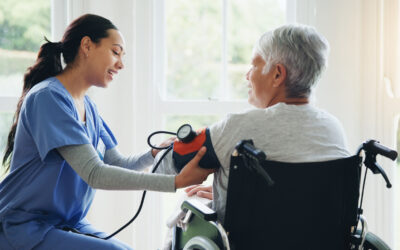 A female nurse or a medical doctor checking the BP of a senior patient